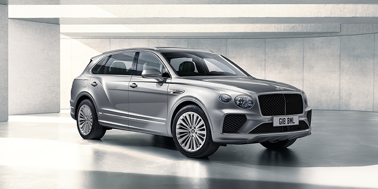 Bentley Lisboa Bentley Bentayga Extended Wheelbase SUV front three quarter in Moonbeam paint with a grey background